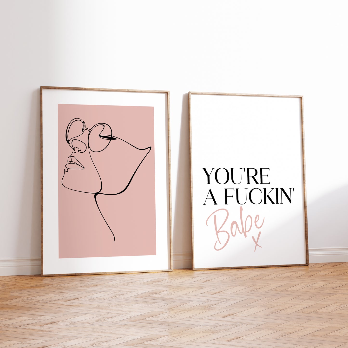 A set of two prints with the left print illustrating a continuous line drawing of a females faces wearing glasses set on a blush pink back ground.
The second print features the quote 'You're a fuckin babe x' which is written in a bold and stylish font.