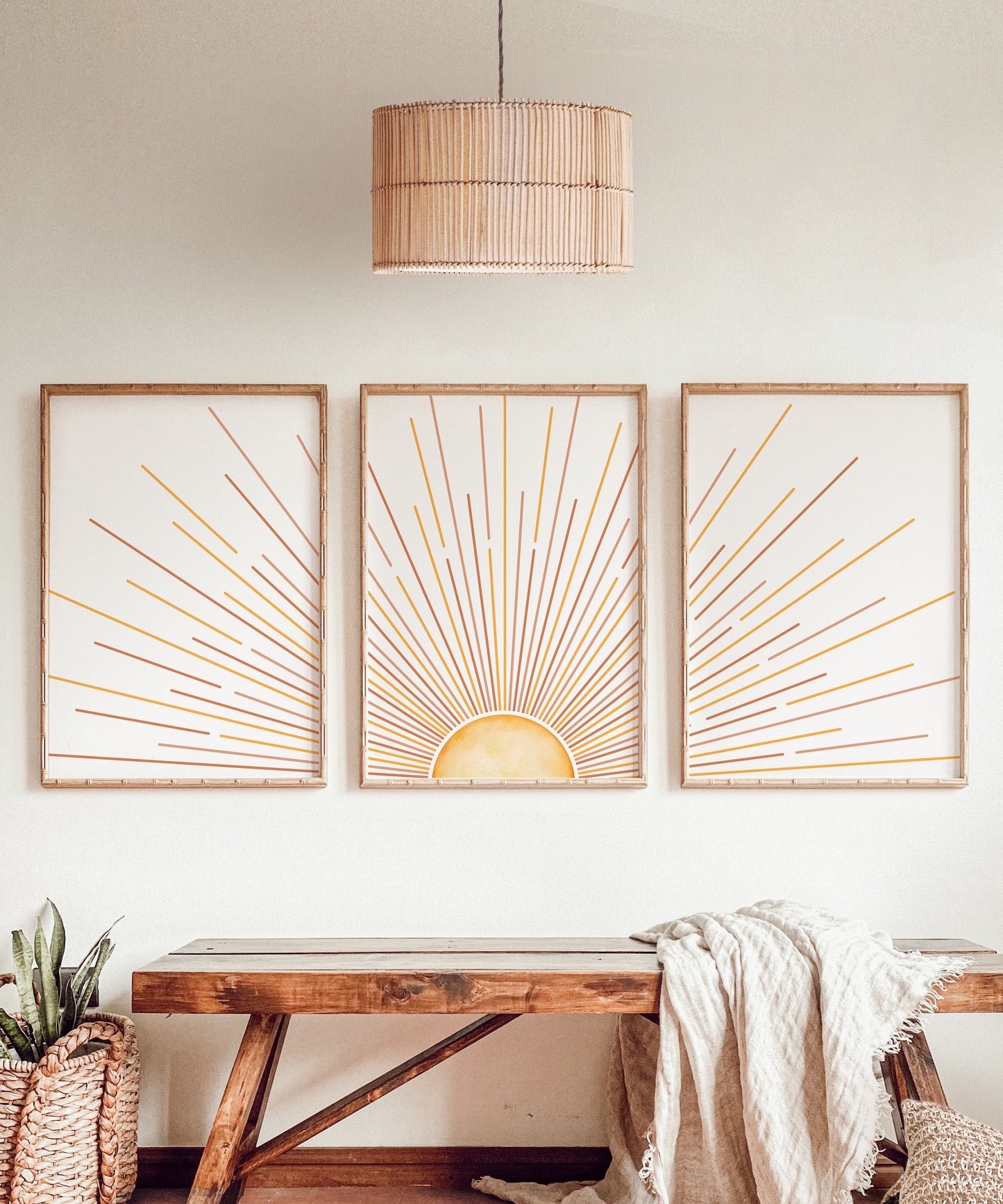A vibrant set of 3 prints illustrating a sunrise in the centre with beaming rays of sunlight in orange and yellow streaks across the pages set on a white background.