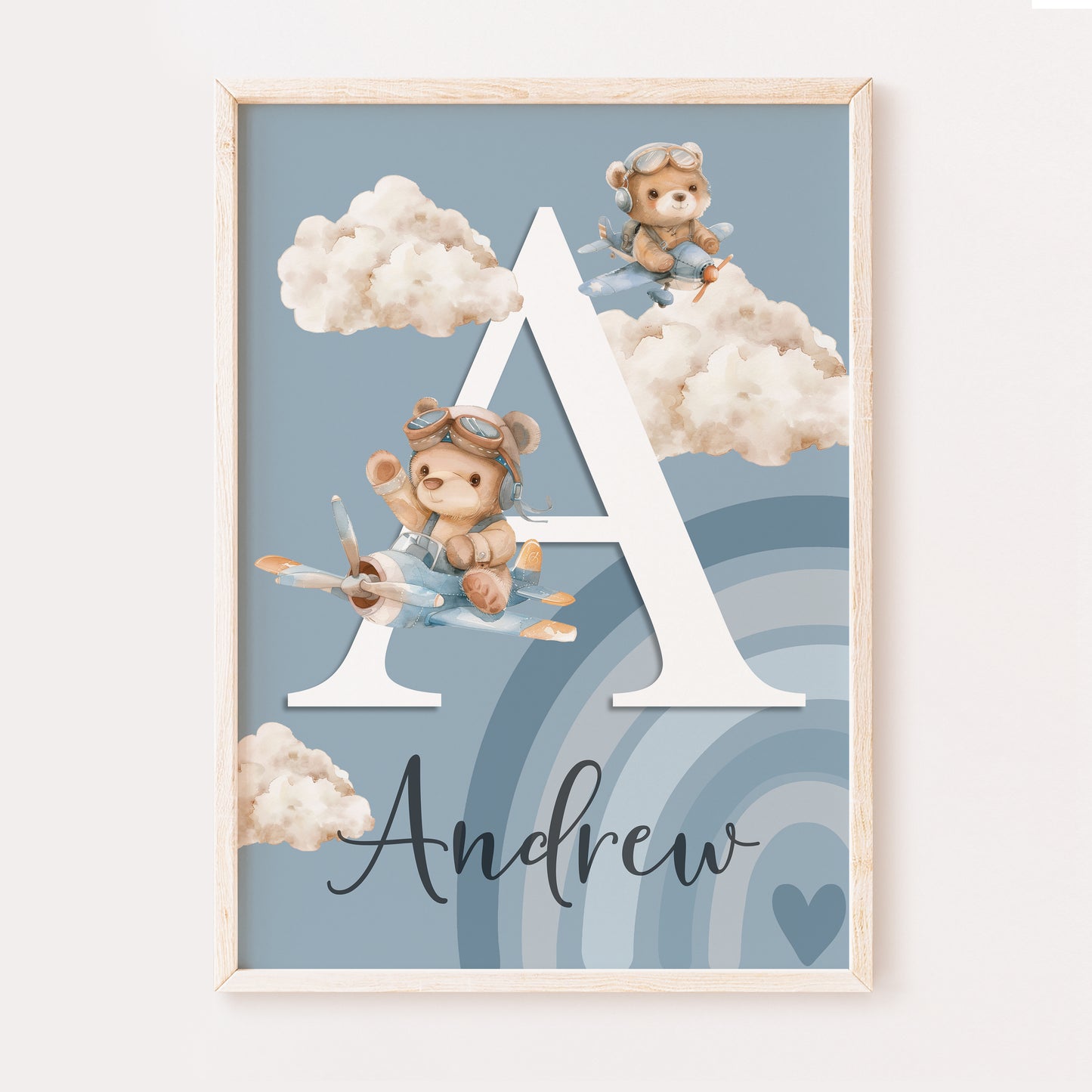 A cute whimsical baby boys nursery print illustrating your childs name written in a fancy font and the first initial in a large white serif font. The design has two teddy bears flying planes through the clouds set on a blue background with a blue rainbow in the corner.