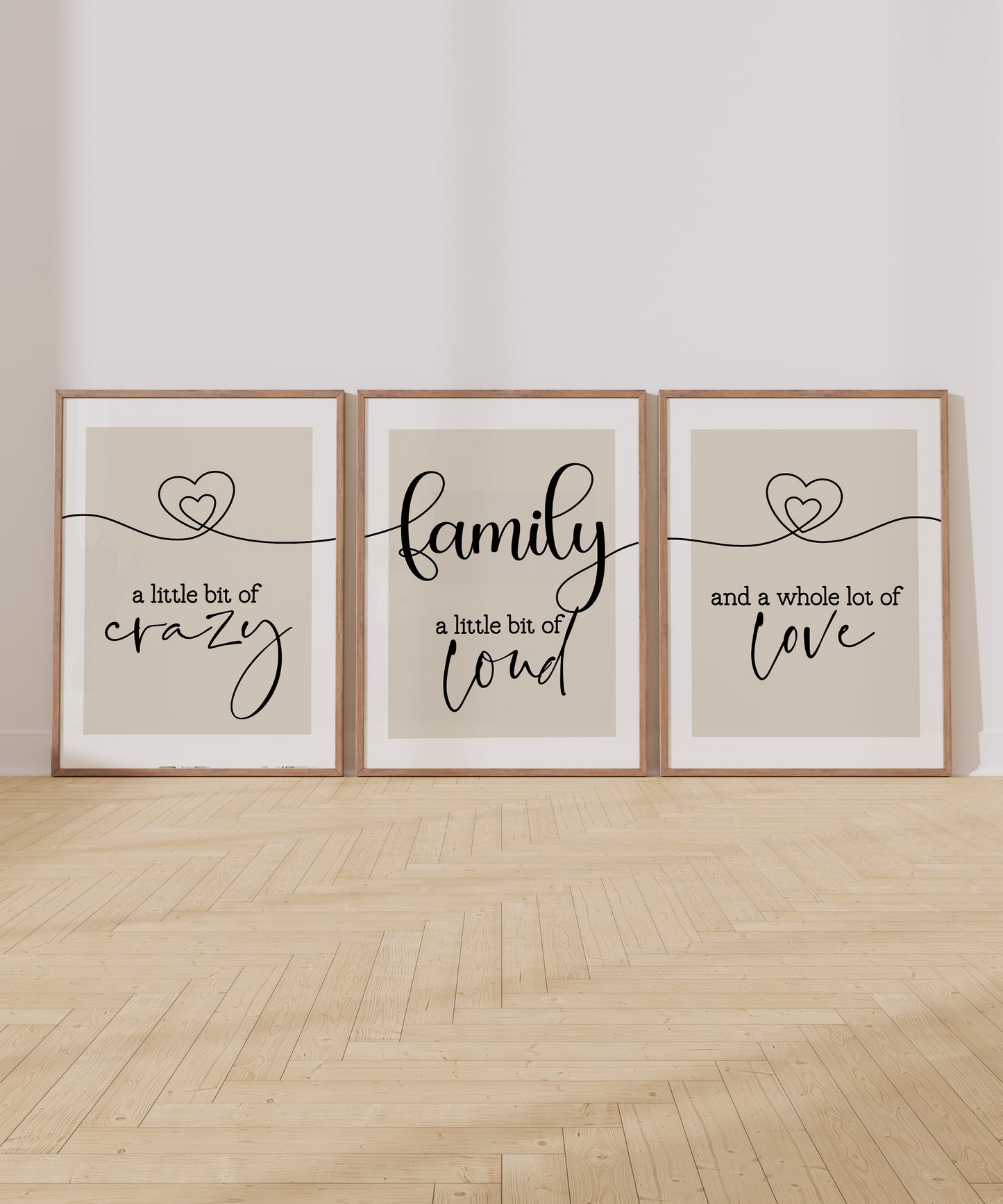 A family quote print set of 3 showing 2 hearts on either side joined in a continuous line with family at the centre and the quotes 'a little bit of crazy', 'a little bit of loud', 'and a whole lot of love'.