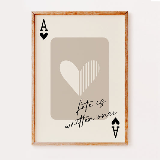 A popular wall art print illustrating an Ace of Hearts playing card in black and beige colours with the quote 'fate is written once' in a hand written black font.