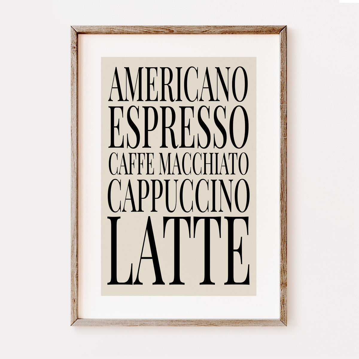 Framed typographic wall art featuring stacked coffee drink names in black serif text on a warm beige background, shown in a light natural wood frame against a white wall.