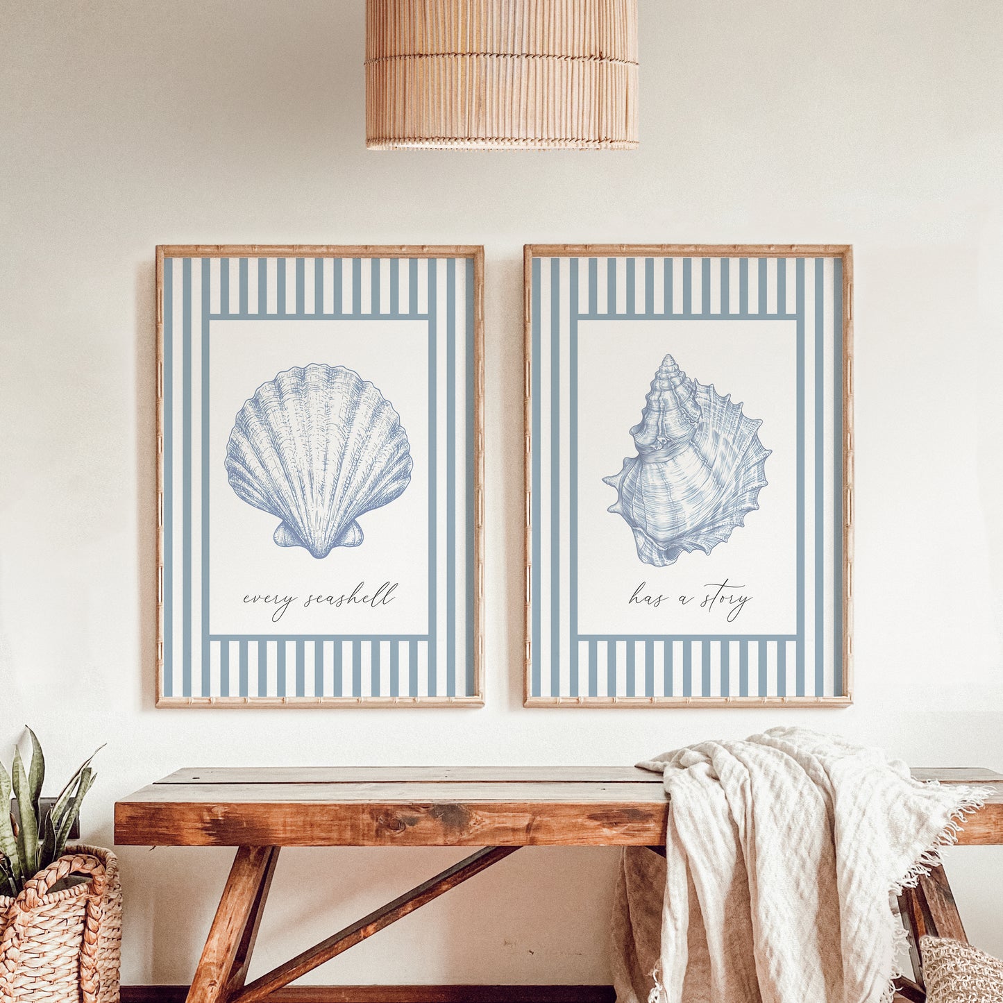 Two framed prints of blue seashells with text on a wall above a wooden bench.