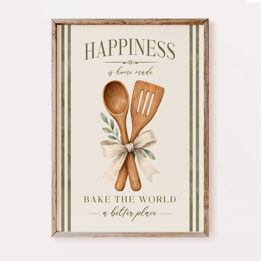 A framed kitchen wall art print with a rustic wood frame, featuring the words “HAPPINESS is home made” and “BAKE THE WORLD a better place,” with two wooden utensils tied with a cream ribbon and small green leaves on an off-white background.
