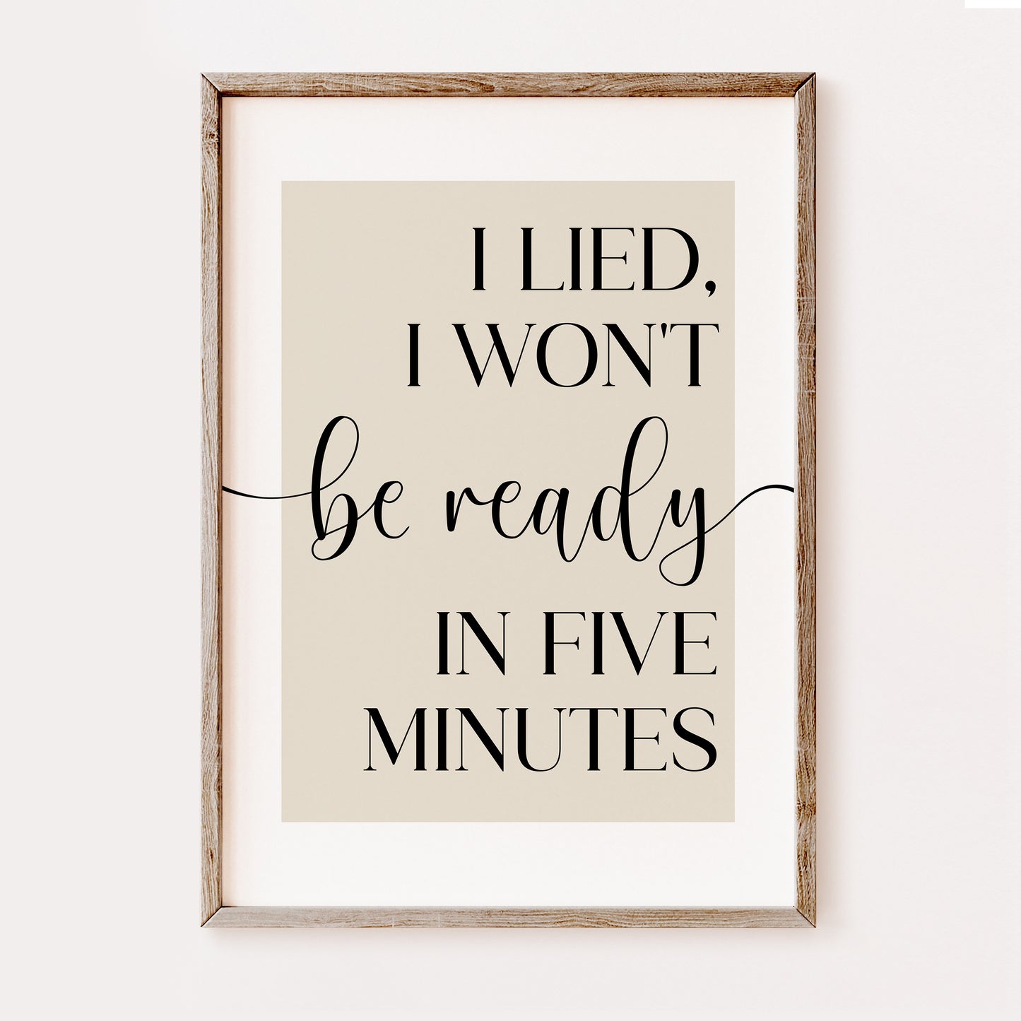 Framed print with humorous quote 'I lied, I won't be ready in five minutes' on a beige background. This makes a wonderful bedroom or dressing room print