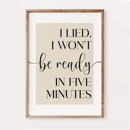 Framed print with humorous quote 'I lied, I won't be ready in five minutes' on a beige background. This makes a wonderful bedroom or dressing room print
