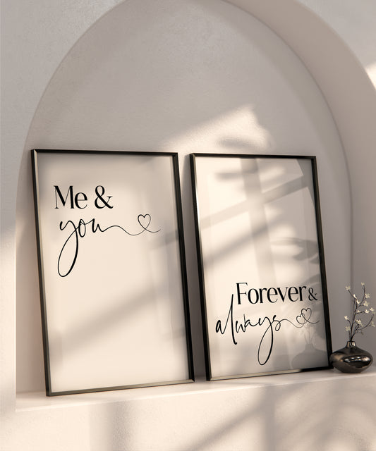 A set of 2 bedroom prints displayed in black frames on a recessed shelf in a wall. The prints read 'Me & You' and 'Forever & Always' written in a sophisticated black font set on a white back ground.
The last letters of 'you' and 'always' have a wavy tail that leads to a little love heart on the end.