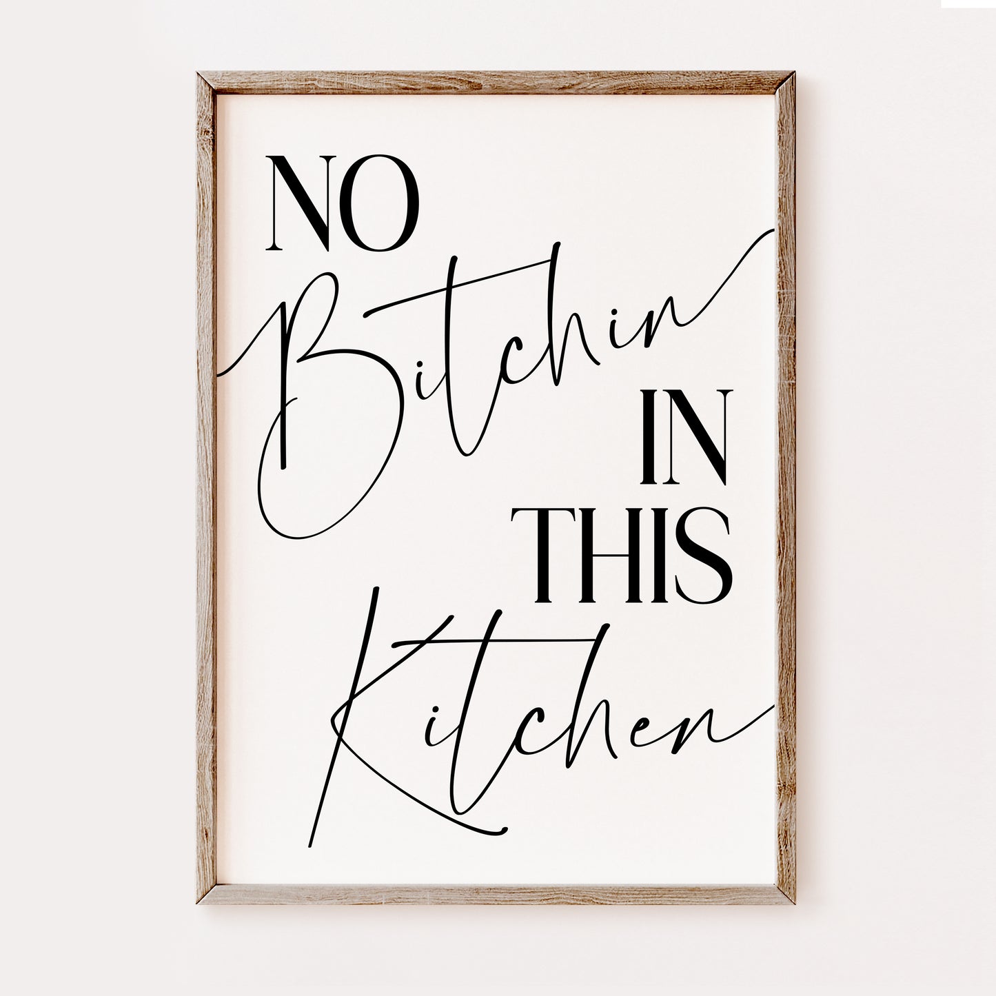 Framed wall art with text 'No Bitchin In This Kitchen' on a white background