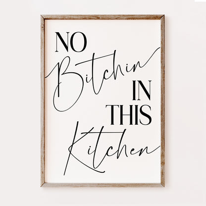 Framed wall art with text 'No Bitchin In This Kitchen' on a white background