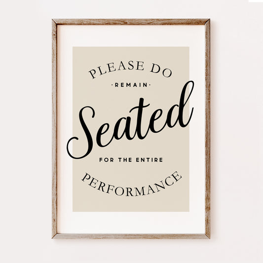 Funny minimalist bathroom wall art print with “Please Remain Seated for the Entire Performance” quote in black typography on a neutral beige background in a wooden frame.