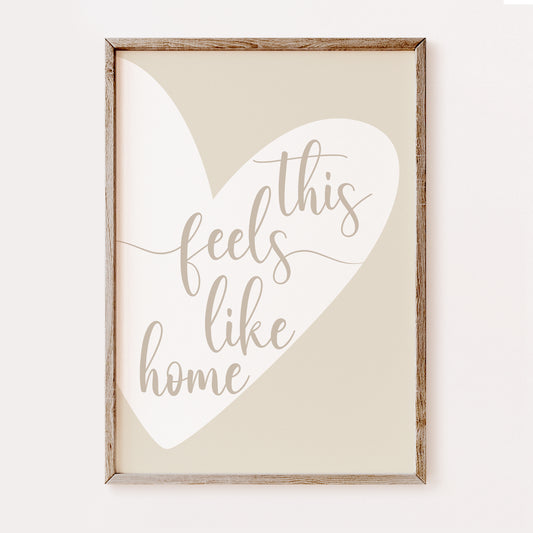 Framed print with a heart shape and text 'this feels like home' on a white background