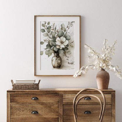 Wooden sideboard with a vase of flowers, framed artwork, and a basket on a light gray wall.
